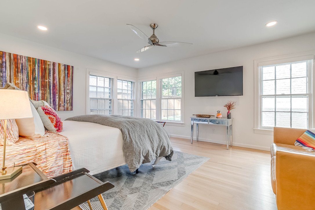 Bright bedroom with a ceiling fan and large windows — Luxury Mountain Retreat