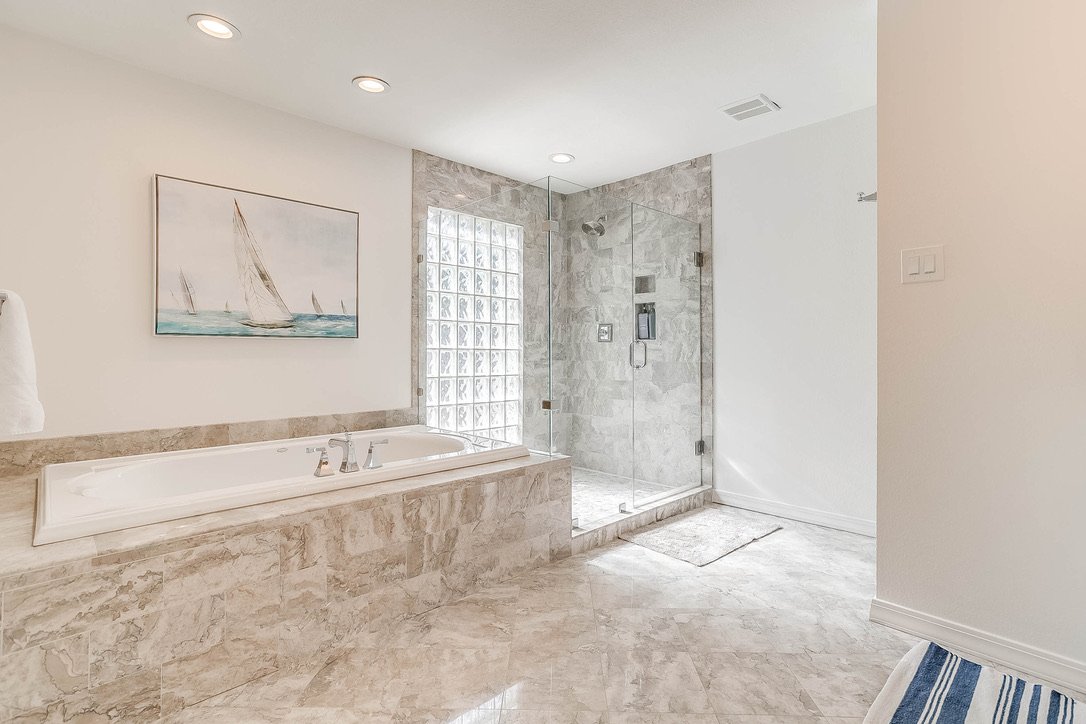 Luxury bathroom with a tiled bathtub and glass shower enclosure — Luxury Mountain Retreat